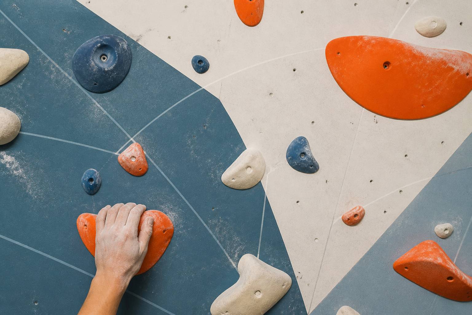 Main a la craie s'accrochant a des prises d'escalade colorees